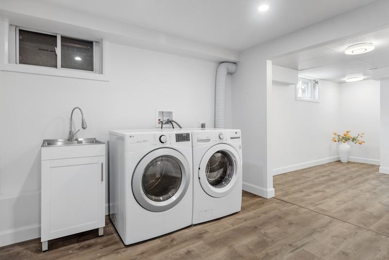 A laundry room with a washer, dryer and utility sink